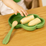 Childs hand reaching out for a banana on a rubber wood Kendall Kale plate for kids by Oli and Carol, for sale at Babipur.
