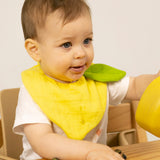 Baby wearing an organic cotton lemon feeding bib, by Oli and Carol, for sale at Babipur.