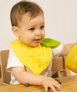 Baby wearing an organic cotton lemon feeding bib, by Oli and Carol, for sale at Babipur.
