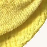 A close up of the  Oli & Carol Lou the lemon baby bib available at Babipur showing the brand name stitch detail on the inside of the bib