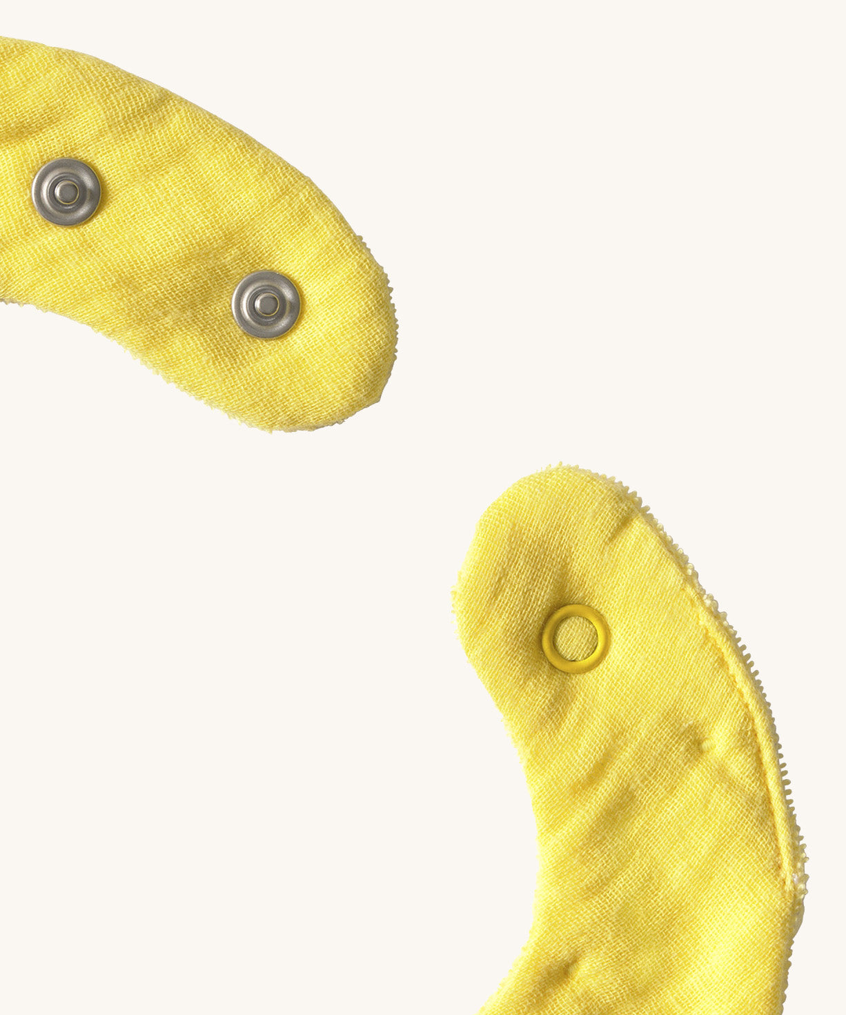 A close up of the  Oli & Carol Lou the lemon baby bib available at Babipur showing the popper fastener for size adjustment. 