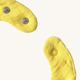 A close up of the  Oli & Carol Lou the lemon baby bib available at Babipur showing the popper fastener for size adjustment. 