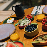 Oli & Carol Lou the lemon wooden bowl on a table available at Babipur showing the bowl filled with blueberries