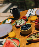 Oli & Carol Lou the lemon wooden bowl on a table available at Babipur showing the bowl filled with blueberries