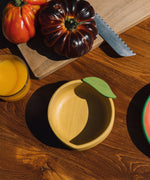 A close up of the Oli & Carol Lou the lemon wooden bowl on a table available at Babipur 