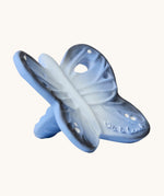 A side view of the Oli & Carol Natural Rubber Mini Teether - Blues The Butterfly, showing the texture of the teether