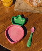 A close up of the Oli & Carol Ramona the radish wooden plate and spoon set available at Babipur on a wooden surface
