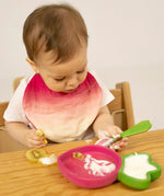 A child eating fruit and yogurt from the Oli & Carol Ramona Radish wooden plate and spoon set available at Babipur. 
