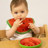 A child eating watermelon from the Oli & Carol Wally the watermelon wooden plate and spoon set available at Babipur. 