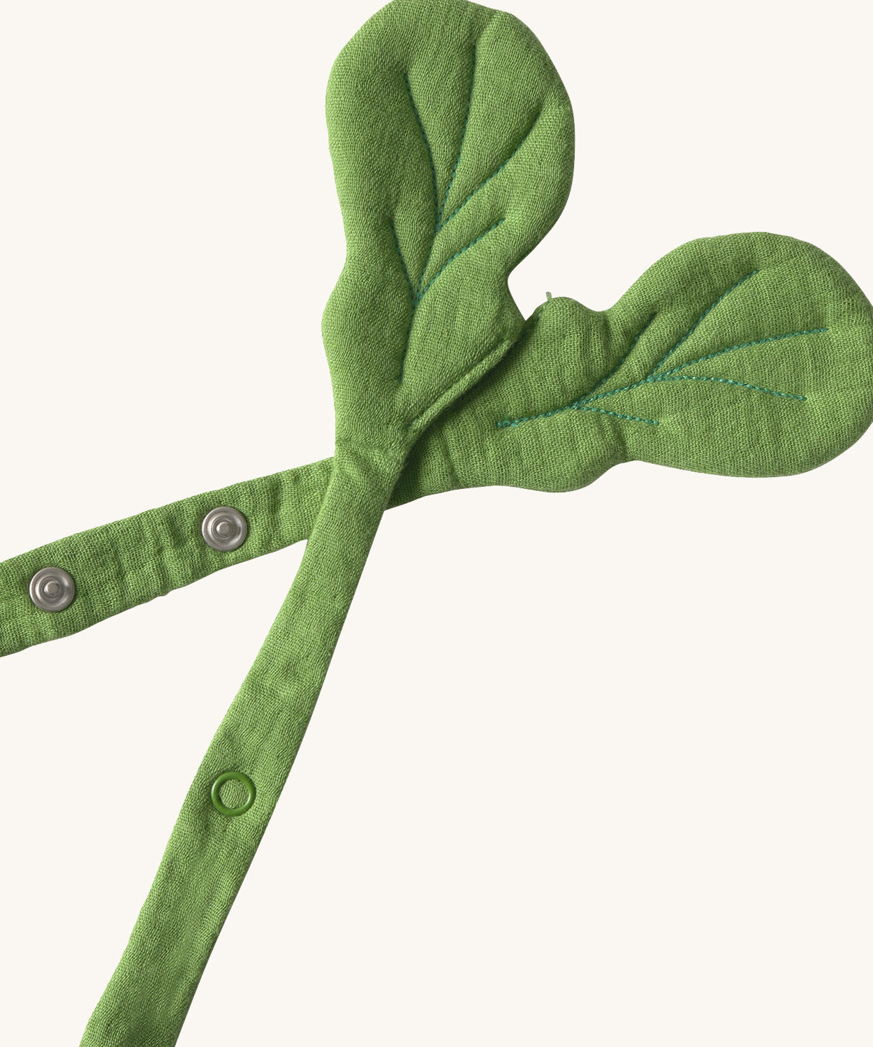 A close up of the  Oli & Carol Ramona the radish baby bib available at Babipur showing the popper fastener for size adjustment. 