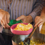 A close up of an adult holding the Oli & Carol Ramona the radish wooden plate available at Babipur. 