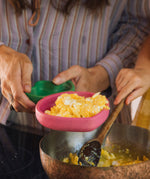 A close up of an adult holding the Oli & Carol Ramona the radish wooden plate available at Babipur. 