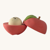 A opened Oli & Carol red apple stacking toy rattle ball available at Babipur. Showing the 2 halves with the core. 