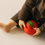 A baby playing with the Oli & Carol red apple stacking toy rattle ball available at Babipur. 