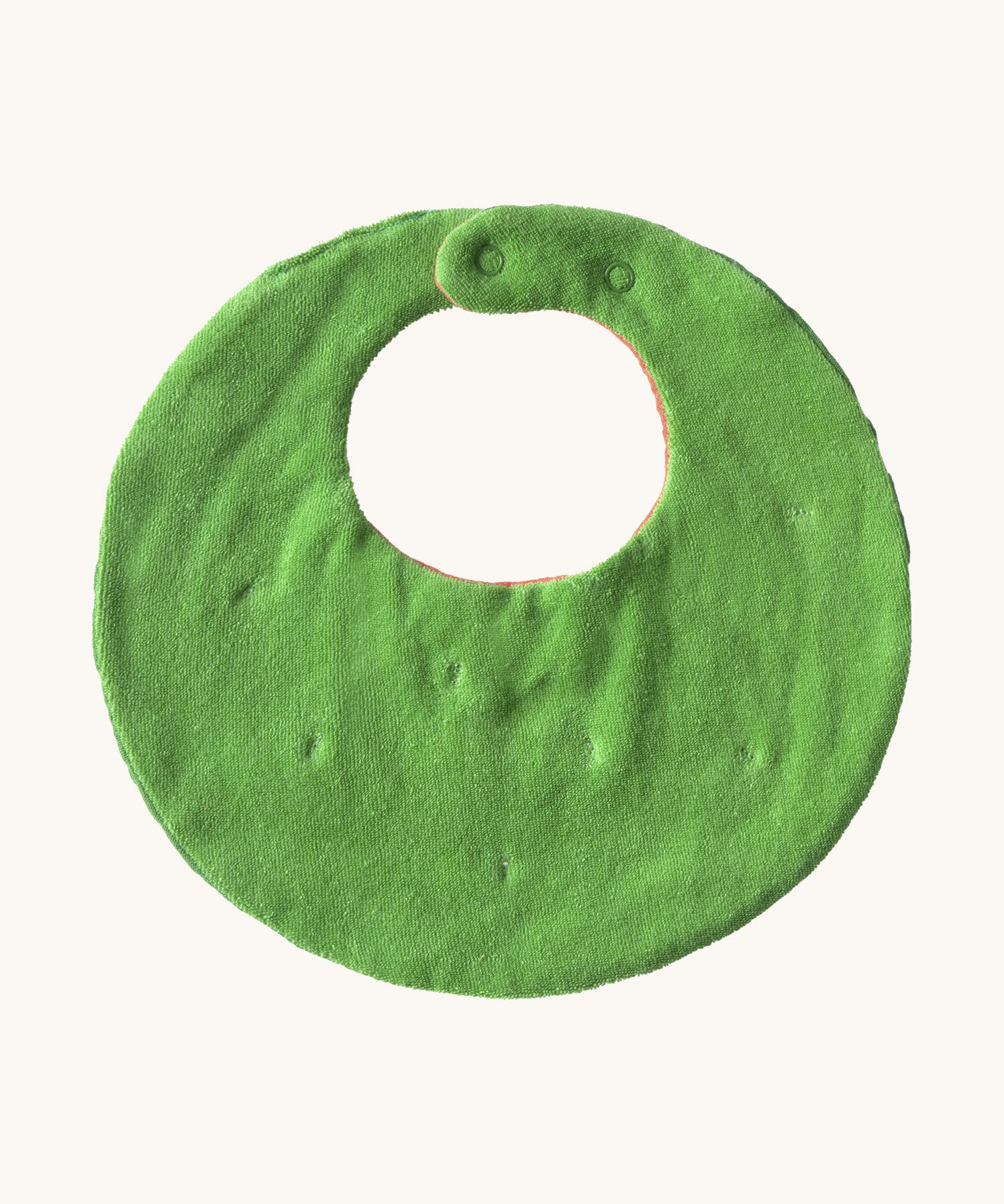 The reverse side of the Oli & Carol Wally the watermelon baby bib available at Babipur. A organic cotton bib in a shape of a watermelon cut in half. Features a popper fastener for size adjustment. 