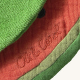 A close up of the  Oli & Carol Wally the watermelon baby bib available at Babipur showing the brand name stitch detail on the inside of the bib