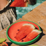 A close up of watermelon slices on the Oli & Carol Wally the watermelon wooden plate and spoon set available at Babipur.