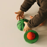 A baby playing with the Oli & Carol watermelon stacking toy rattle ball available at Babipur. 
