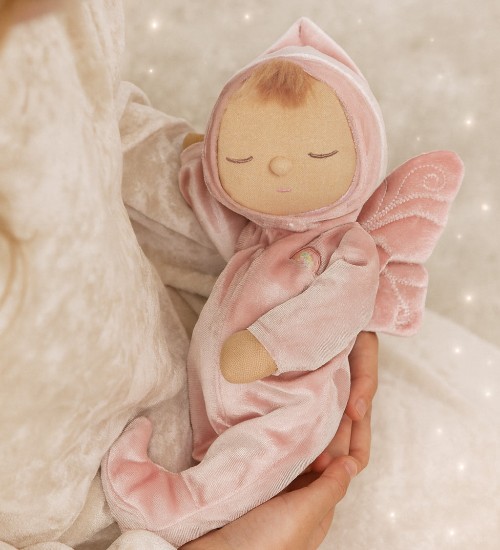 A child holding the pink Olli Ella Aurora fairy dozy dinkum doll 