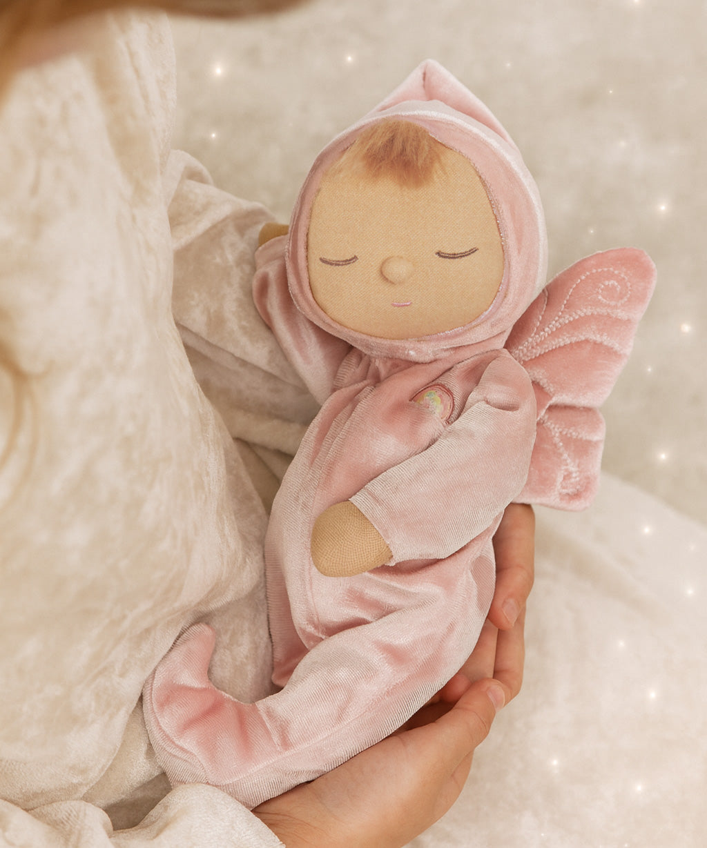 A child holding the pink Olli Ella Aurora fairy dozy dinkum doll 