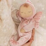 A child holding the pink Olli Ella Aurora fairy dozy dinkum doll 