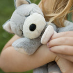 A child holding the soft grey Olli Ella dinkum puppy.
