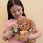 A child holding a Goldie Olli Ella dinkum dog and a Benny Olli Ella dinkum puppy