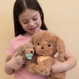 A child holding a Goldie Olli Ella dinkum dog and a Benny Olli Ella dinkum puppy