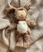 A Olli Ella cozy dinkum dog Digby doll lying on a blanket showing it's cute floppy ears and sleeping face. This soft toy doll is available at Babipur.