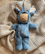 Olli Ella cozy dinkum bunny twiggy doll in blue colour lying on top of a soft blanket. This fluffy toy doll is available at Babipur