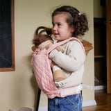 A child carrying a Olli Ella dinkum doll with the Olli Ella toy carrier in rose . This toy carrier is available at Babipur.