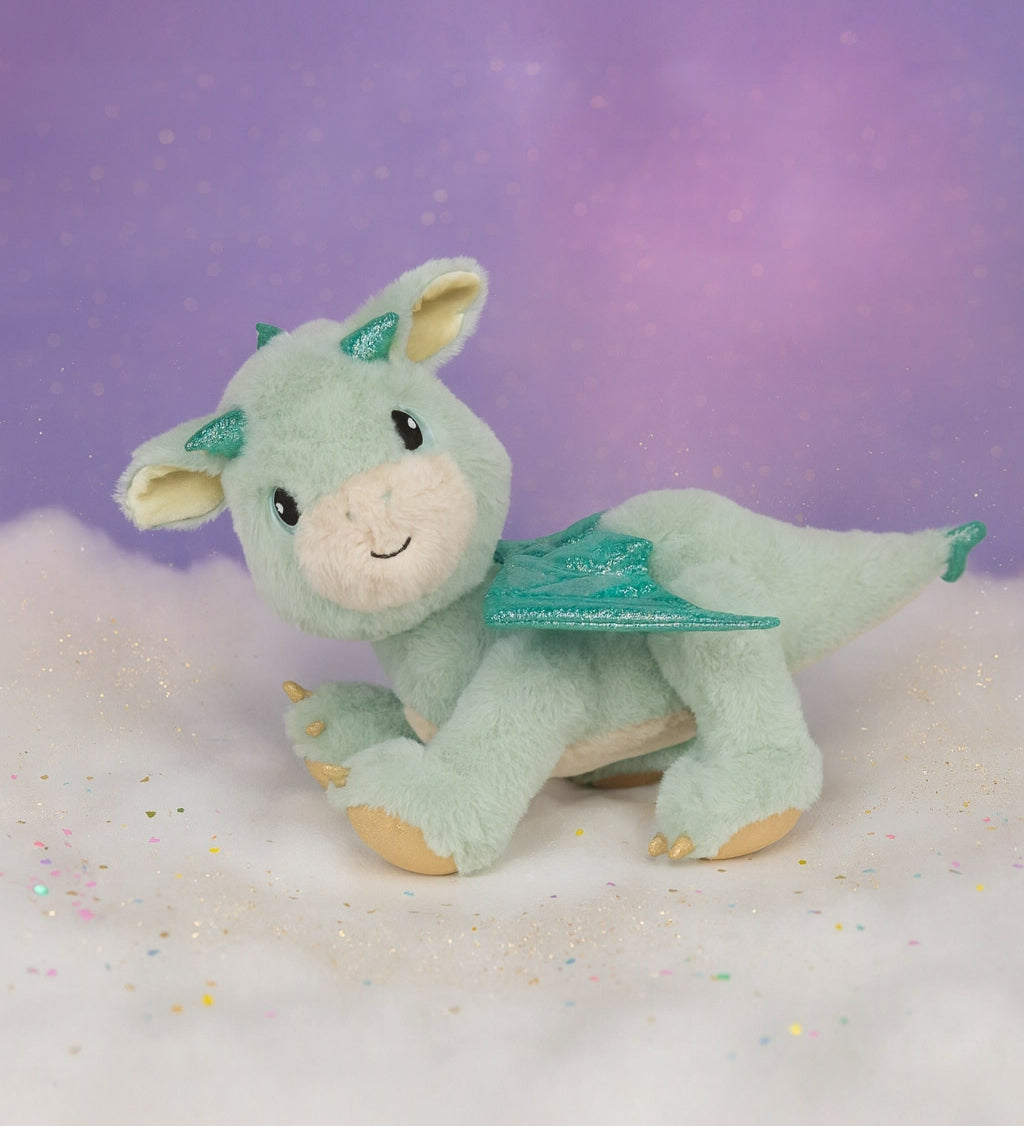 A Olli Ella dinkum dragon blaze doll standing on a fully cloud. This light green fluffy doll has movable limbs and features green glittery wings. This doll is available at Babipur.