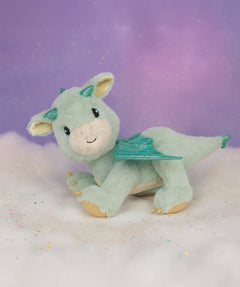 A Olli Ella dinkum dragon blaze doll standing on a fully cloud. This light green fluffy doll has movable limbs and features green glittery wings. This doll is available at Babipur.