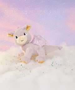 A Olli Ella dinkum dragon flare doll standing on a fully cloud. This light pink fluffy doll has movable limbs and features pink glittery wings. This doll is available at Babipur.