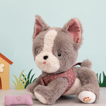 A grey and white Gizmo Olli Ella dinkum dog sitting next to its pink magnetic bone