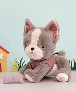 A grey and white Gizmo Olli Ella dinkum dog sitting next to its pink magnetic bone