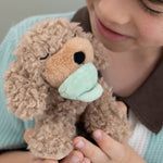 A child holding the soft and fluffy brown Benny Olli Ella dinkum doll