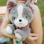 A child hugging the Olli Ella Gizmo dinkum dog. 