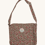 Olli Ella Carrie Convertible Changing Set - Garland. A beautiful floral print, cotton, changing bag for dolls and toys, with an adjustable shoulder strap. The changing bag coverts into a changing mat with the same floral print. The image is on a cream background