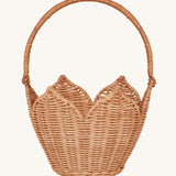Olli Ella Rattan Poinsettia Carry Basket is a beautiful scalloped, handwoven, rattan basket in a light brown, with a carry handle. The basket is on a cream background.