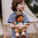 A child playing outside and holding a dinkum doll that's wearing the Olli Ella rambler dinkum doll outfit set available at Babipur. 