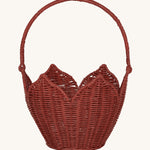 Olli Ella Rattan Poinsettia Carry Basket is a beautiful scalloped, handwoven, rattan basket in a poinsettia red colour, with a carry handle. The basket is on a cream background.