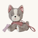 Olli Ella Dinkum Dog - Gizmo is an adorable, soft dog with grey and white plush fur, and wears a dark pink harness with white spots, and has a plush dark pink bone