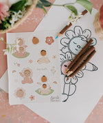The stickers from the Olli Ella Limited Edition Blossom Buds Gift Set - Tulip, on a table with Olli Ella pencils and an Olli Ella Blossom Buds drawing