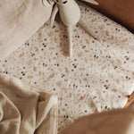 The Grasslands fitted bed sheet on a bed with toys