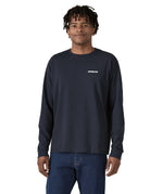 A person wearing the Patagonia L/S P-6 Logo Responsibili-Tee - New Navy, showing the fit from the front