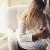 A mother feeding her baby on an Avery Row Nursing Pillow - Waves.