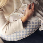 A mother feeding her baby on an Avery Row Nursing Pillow - Waves.