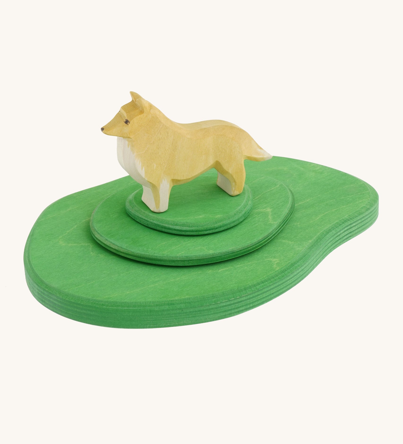 A Ostheimer wooden collie dog figure standing on top of the 3 piece meadow set available at Babipur to show scale. Set is perfect for play scenes and displays
