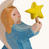 A close up of the blur Ostheimer wooden angel figure holding a star, available at Babipur showing the hand painted detail